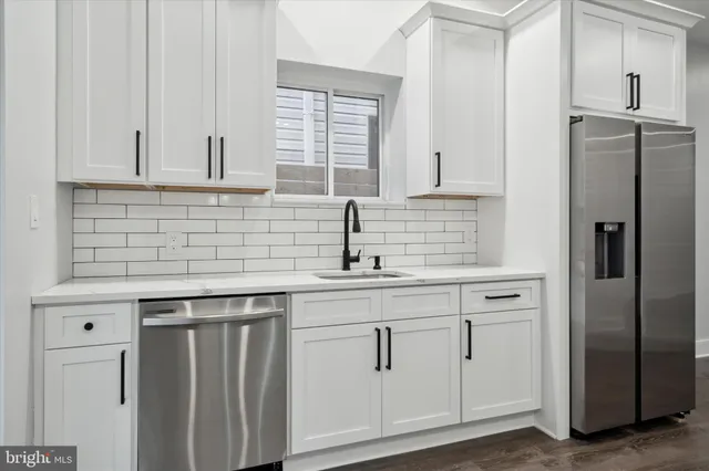a kitchen with white cabinets and a refrigerator
