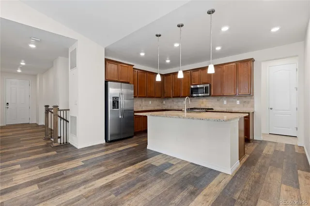 a view of kitchen with cabinets appliances and wooden floor