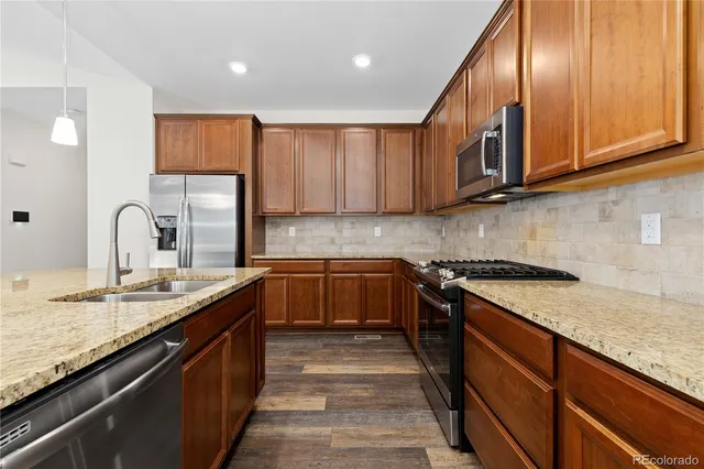 a kitchen with stainless steel appliances granite countertop a sink stove and cabinets