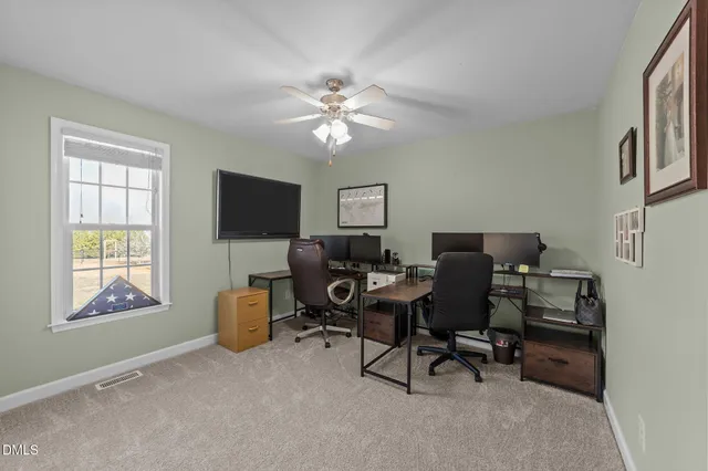 a view of a workspace with furniture and a window