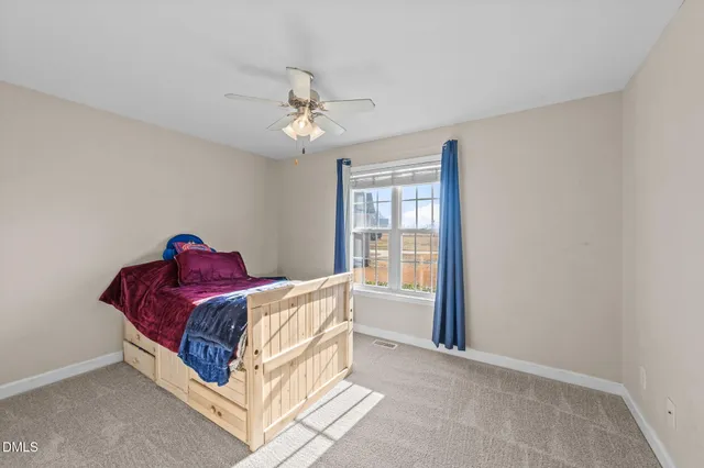 a bed sitting in a bedroom next to a window