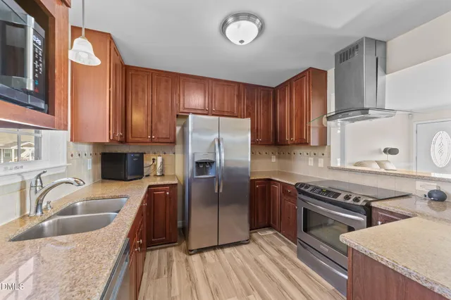 a kitchen with stainless steel appliances granite countertop a sink stove and refrigerator
