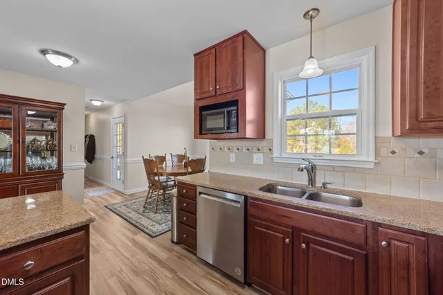a kitchen with stainless steel appliances granite countertop a sink stove and microwave
