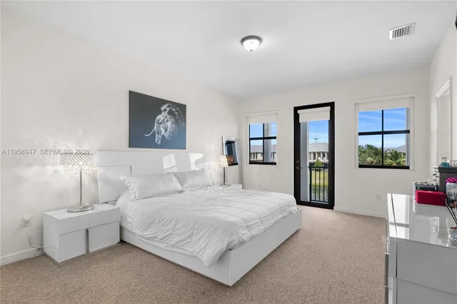 a bedroom with a large bed and a potted plant