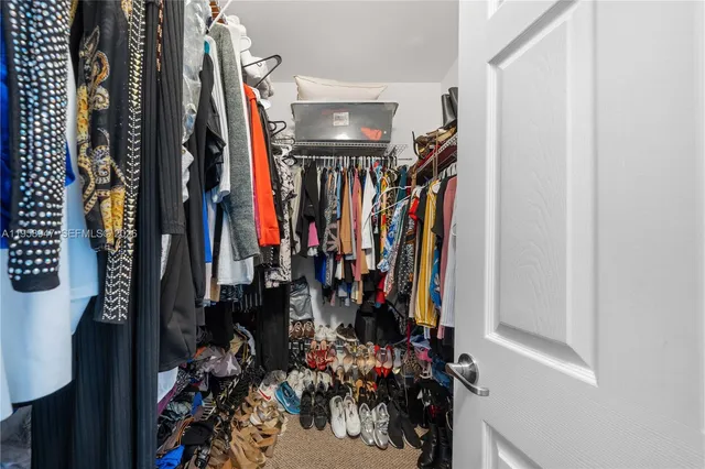 a view of walk in closet with clothes