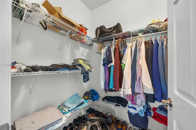 a view of walk in closet with clothes and shoes