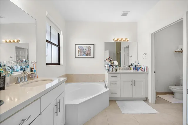 a bathroom with a tub sink and mirror