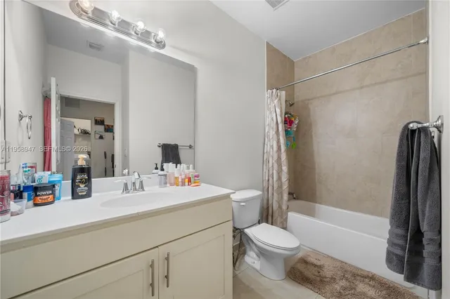 a bathroom with a sink a toilet a mirror and shower