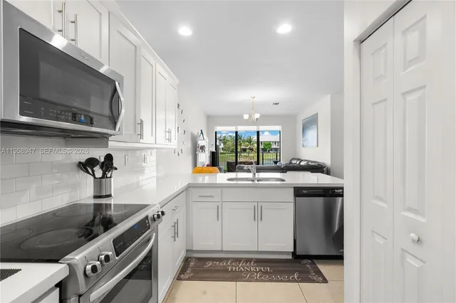 a kitchen with stainless steel appliances a sink stove and cabinets
