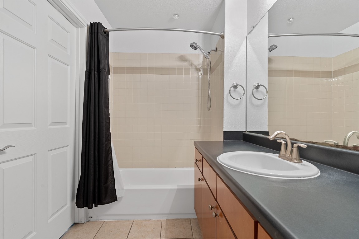 2515 Pearl Street, Unit 102 Austin, TX 78705 - Photo 16 of 30 Bathroom featuring light tile patterned floors, shower / bathtub combination with curtain, and vanity
