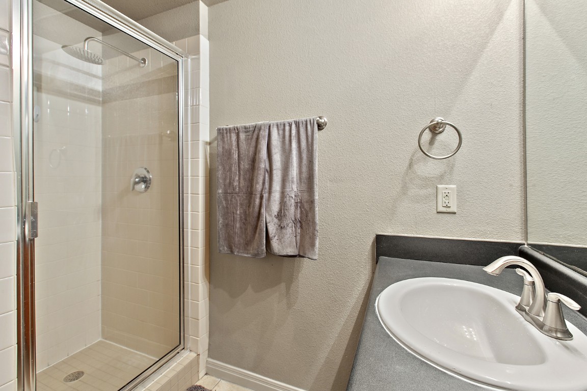 2515 Pearl Street, Unit 102 Austin, TX 78705 - Photo 2 of 30 Bathroom with a textured wall, a shower stall, and vanity