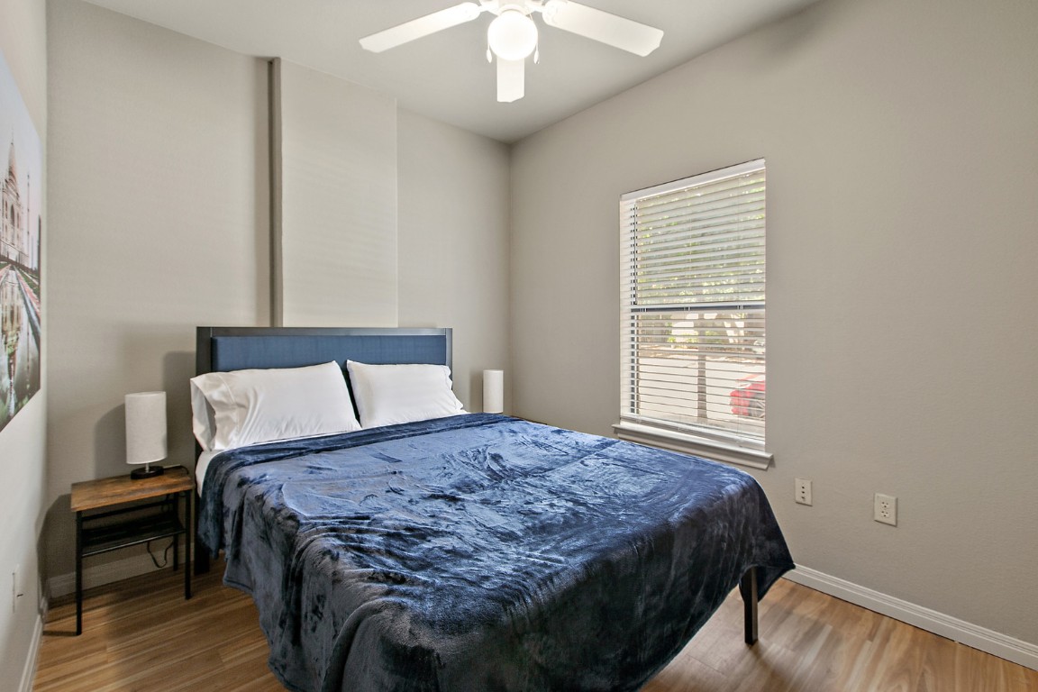 2515 Pearl Street, Unit 102 Austin, TX 78705 - Photo 4 of 30 Bedroom featuring wood finished floors and ceiling fan