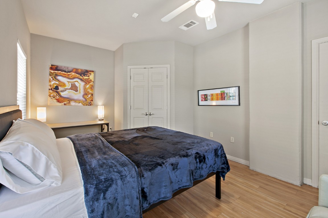 2515 Pearl Street, Unit 102 Austin, TX 78705 - Photo 5 of 30 Bedroom featuring wood finished floors, a ceiling fan, and a closet