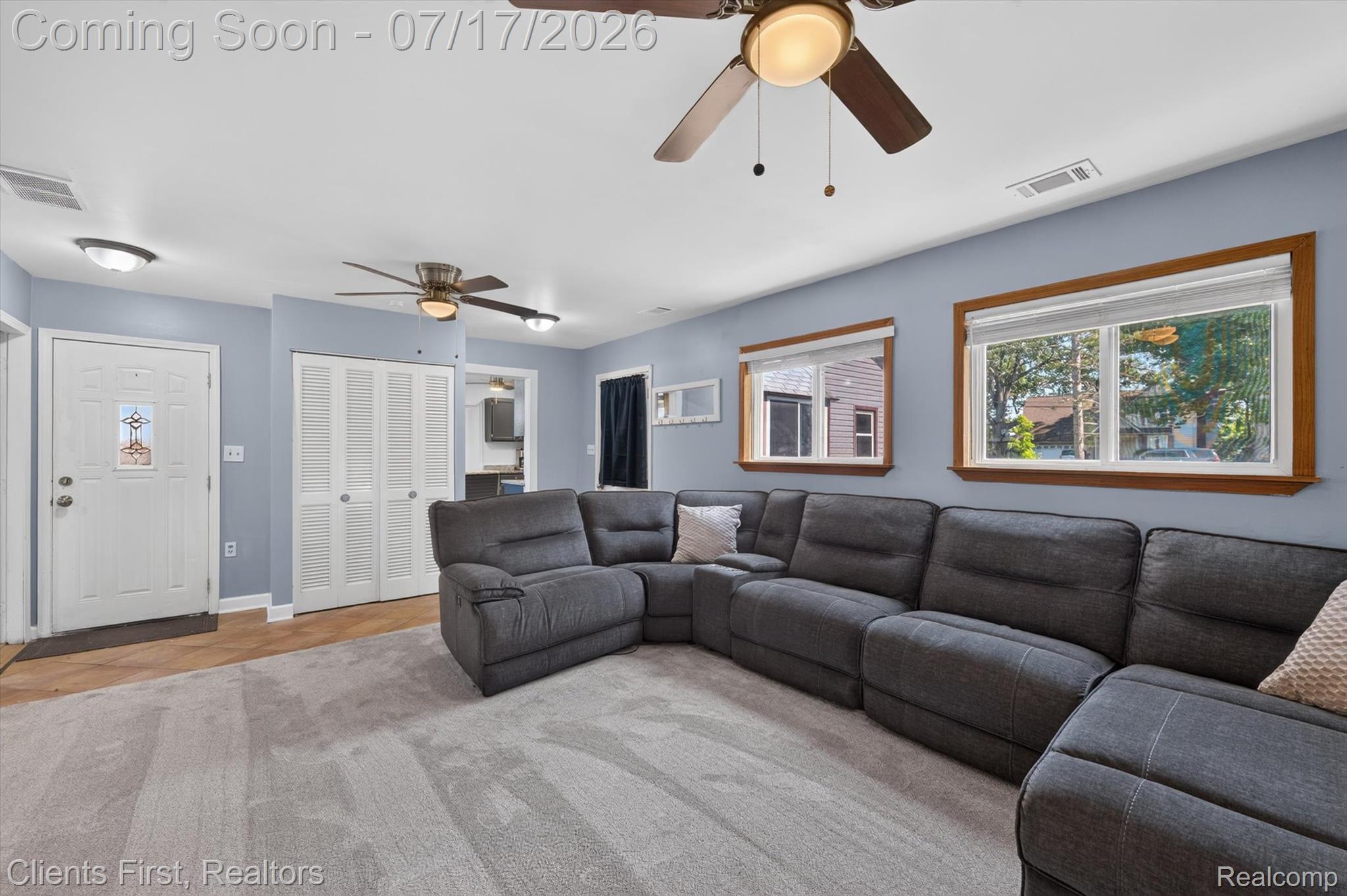 36852 Chase Street Romulus, MI 48174 - Photo 6 of 40 Spacious living area featuring light blue walls, a light gray carpet, and a wood-finish flooring entryway