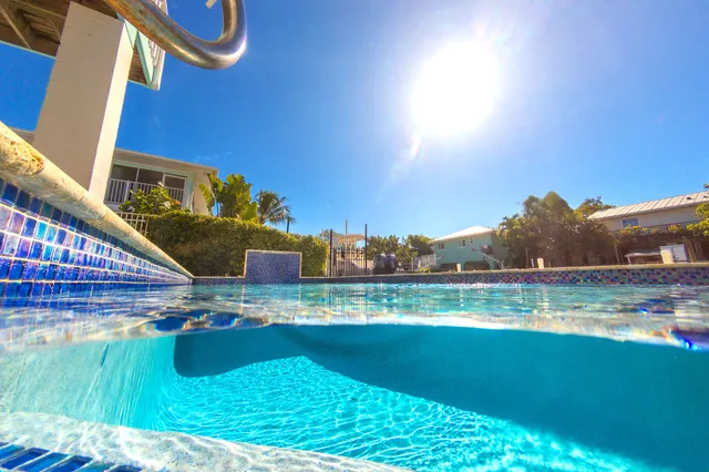 an aerial view of a house with swimming pool and outdoor seating
