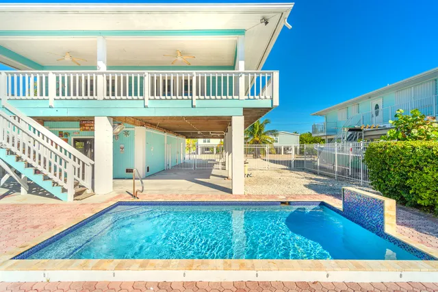 an aerial view of a house with a garden and lake view