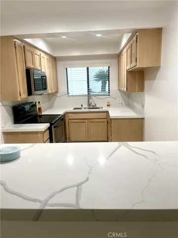 a large kitchen with kitchen island granite countertop a sink and a stove