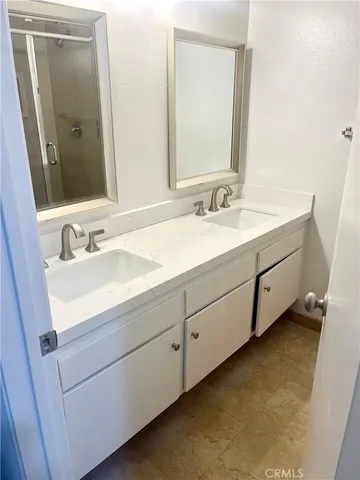 a bathroom with a double vanity sink and mirror