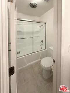 a bathroom with a toilet and a shower