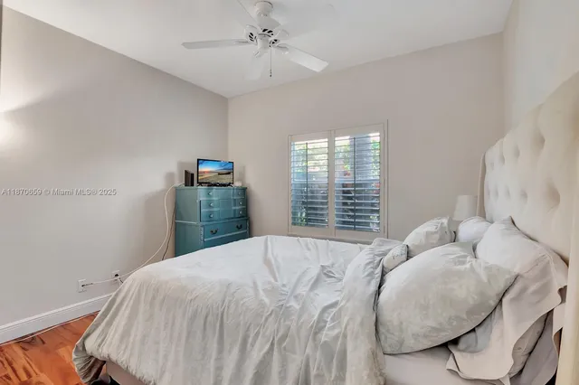a bedroom with a large bed and a flat tv screen on dresser