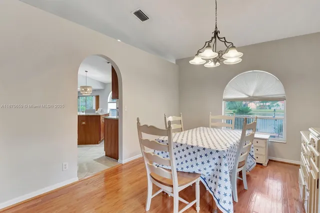 a view of a dining room with furniture wooden floor and chandelier