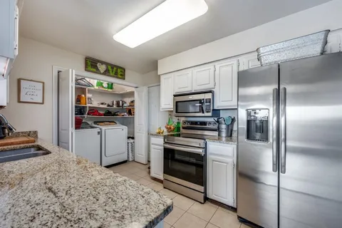 a kitchen with a refrigerator stainless steel appliances