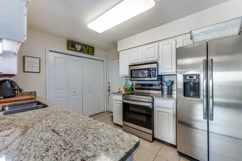 a kitchen with stainless steel appliances granite countertop a refrigerator and a sink