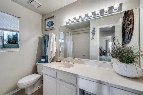 a bathroom with a toilet a sink and mirror