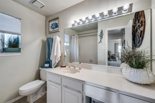 a bathroom with a toilet a sink and mirror