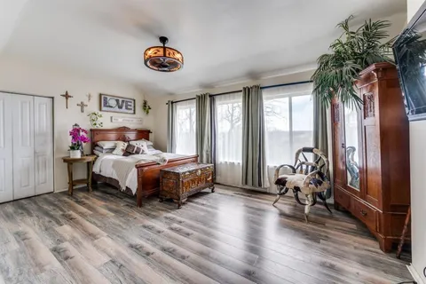 a bedroom with a bed and a large window