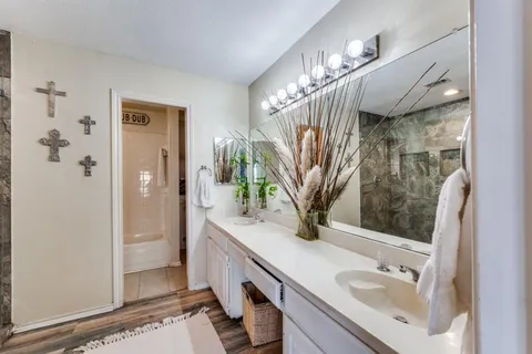 a bathroom with a sink a mirror and a shower