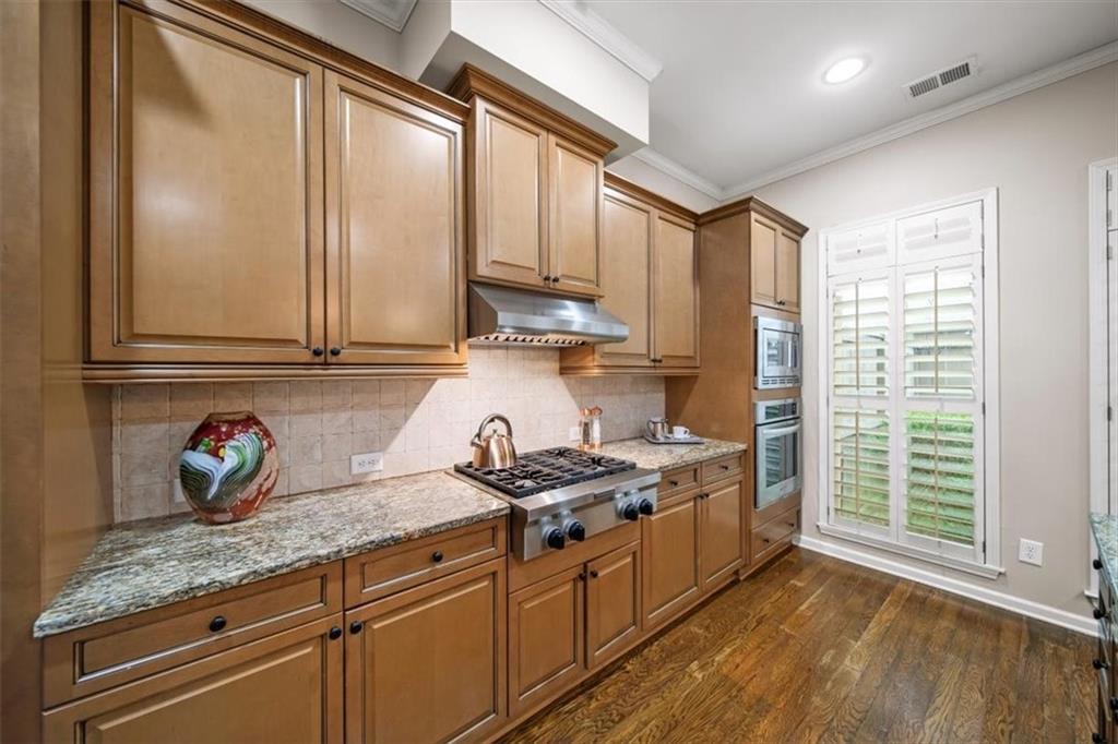5564 High Point Road Northeast Atlanta, GA 30342 - Photo 11 of 45 a kitchen with stainless steel appliances granite countertop a sink a stove and a wooden floor