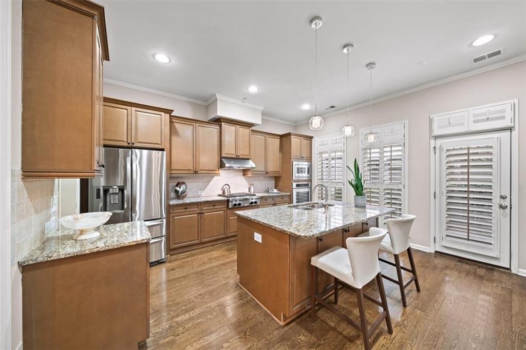 5564 High Point Road Northeast Atlanta, GA 30342 - Photo 8 of 45 a kitchen with granite countertop kitchen island stainless steel appliances a sink a stove a refrigerator cabinets and living room view