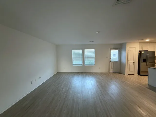 an empty room with wooden floor and a window