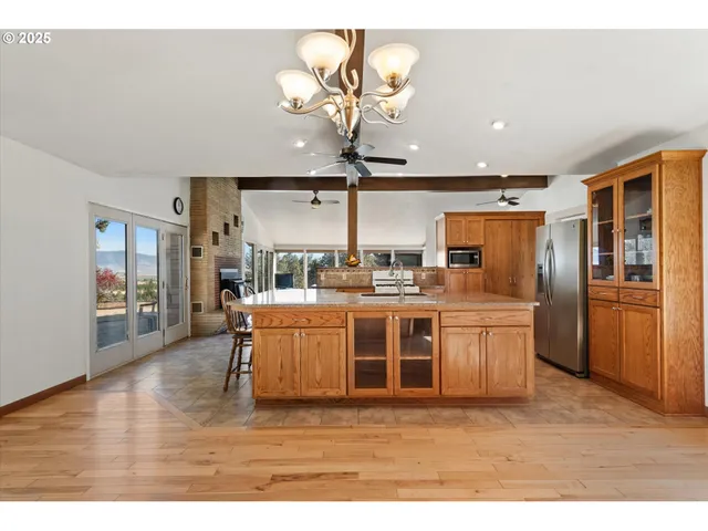 a kitchen with stainless steel appliances granite countertop a refrigerator a sink dishwasher a stove with wooden cabinets