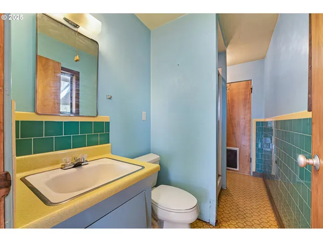 a living room with stainless steel appliances furniture and a kitchen view