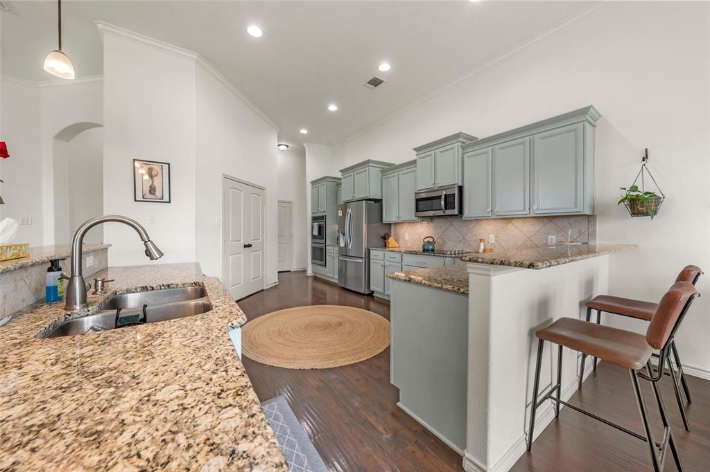 4756 Old Lorena Road Lorena, TX 76655 - Photo 13 of 39 a kitchen with sink a refrigerator and chairs