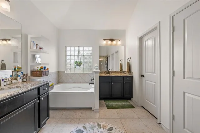 a bathroom with a tub a sink and mirror