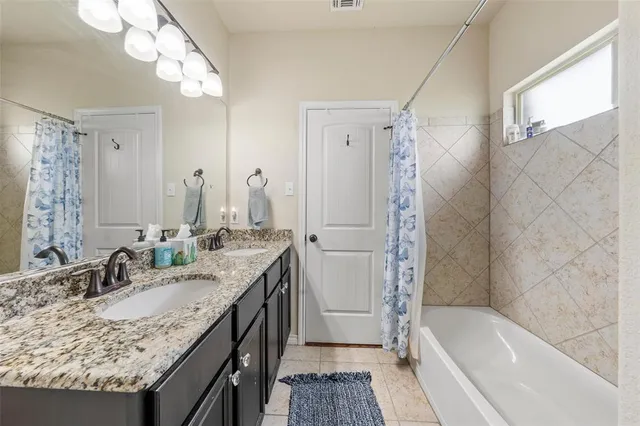 a bathroom with a granite countertop sink mirror and a bath tub