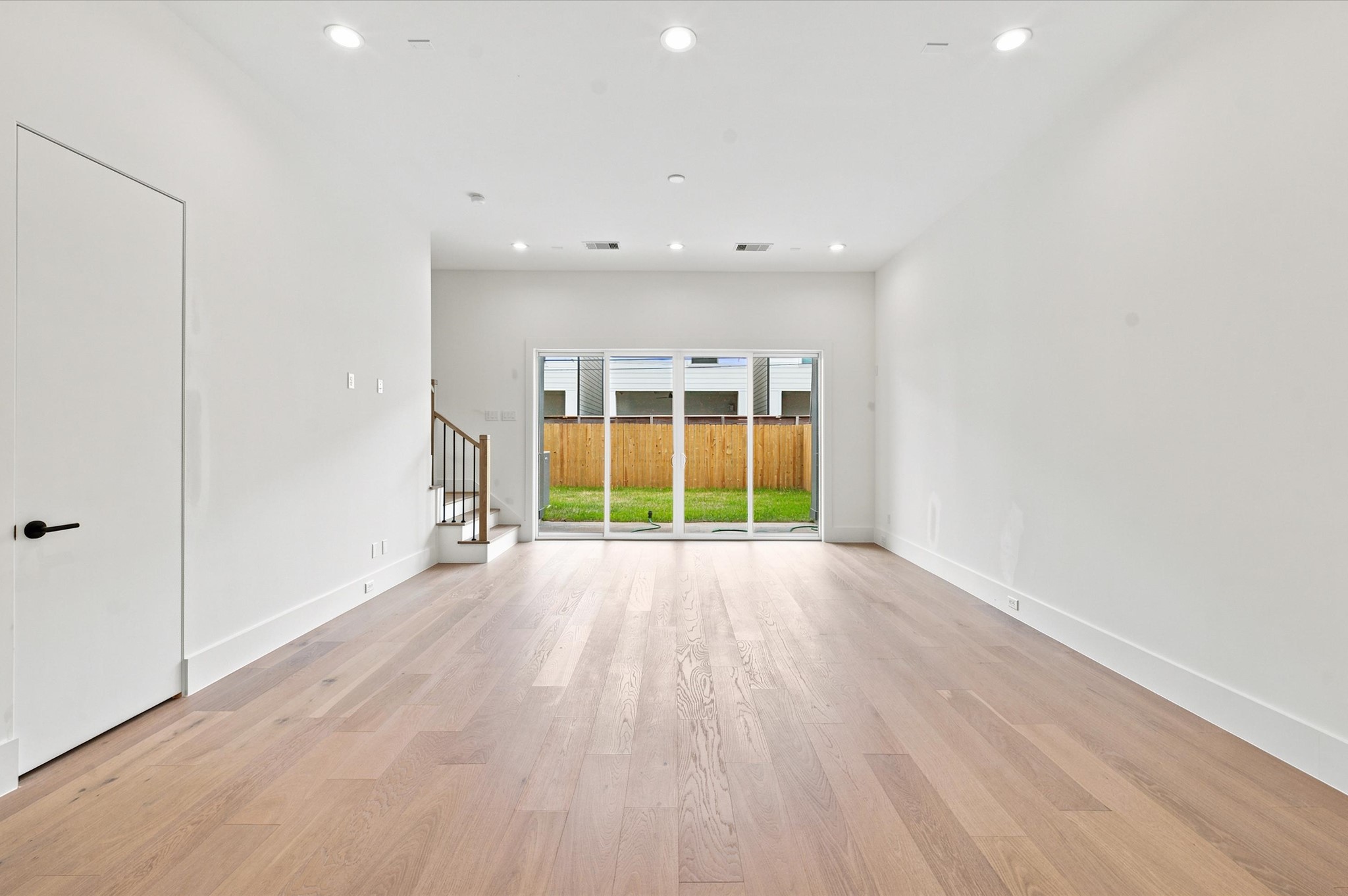 112 East 27th Street Houston, TX 77008 - Photo 7 of 43 Sliding glass doors create a seamless transition from the living room to the expansive covered patio and private fenced backyard.