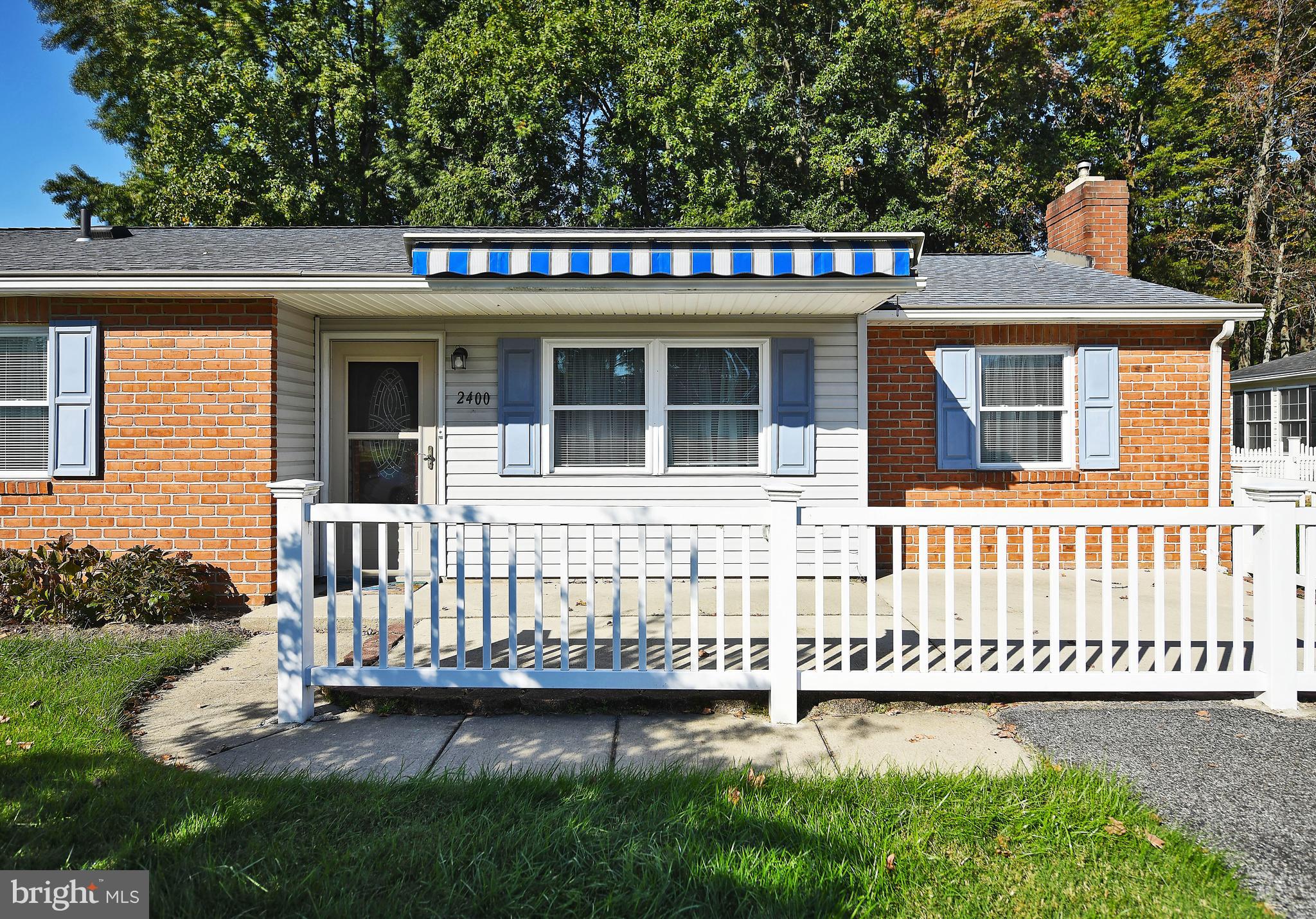 2400 Maple Road Baltimore, MD 21219 - Photo 45 of 45 a front view of a house with a garden and bench