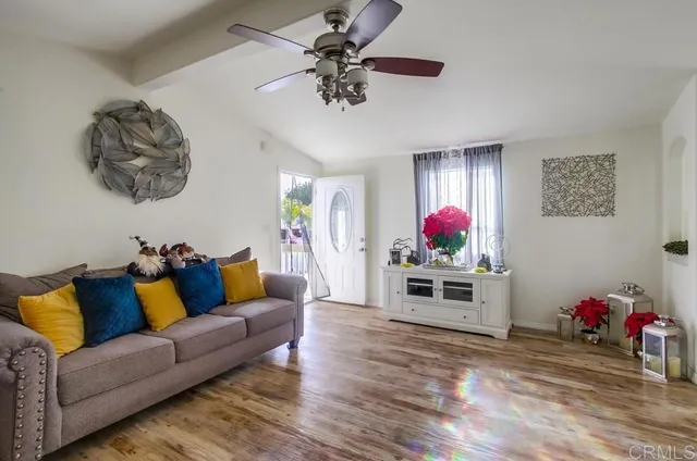 a living room with furniture kitchen view and a window