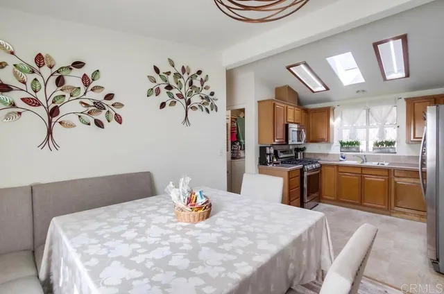 a kitchen with stainless steel appliances kitchen island granite countertop a table chairs a stove a microwave and cabinets