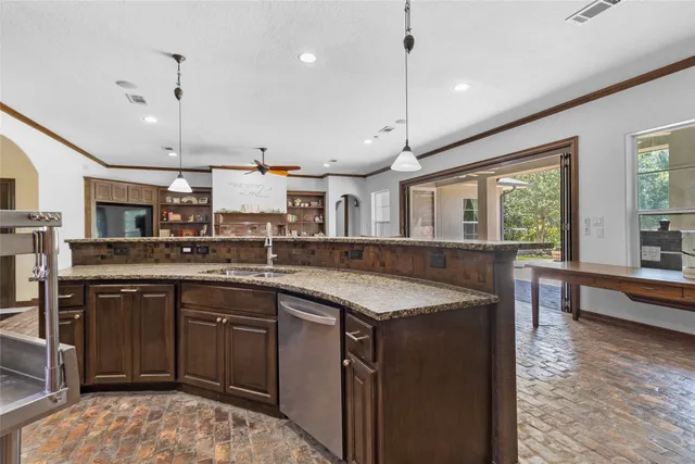 a kitchen with stainless steel appliances granite countertop a sink a stove and a wooden floors