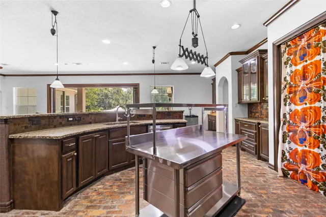 a kitchen with stainless steel appliances granite countertop a sink a stove and a wooden floors