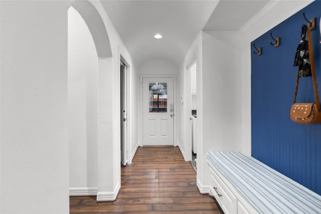 a view of a hallway with wooden floor and furniture