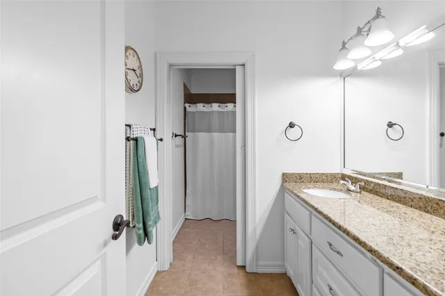 a bathroom with a granite countertop sink toilet a mirror and shower
