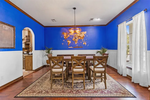 a view of a dining room with furniture a rug and wooden floor