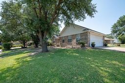 a view of a house with backyard and a tree