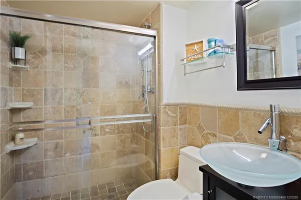 a bathroom with a sink mirror toilet and shower